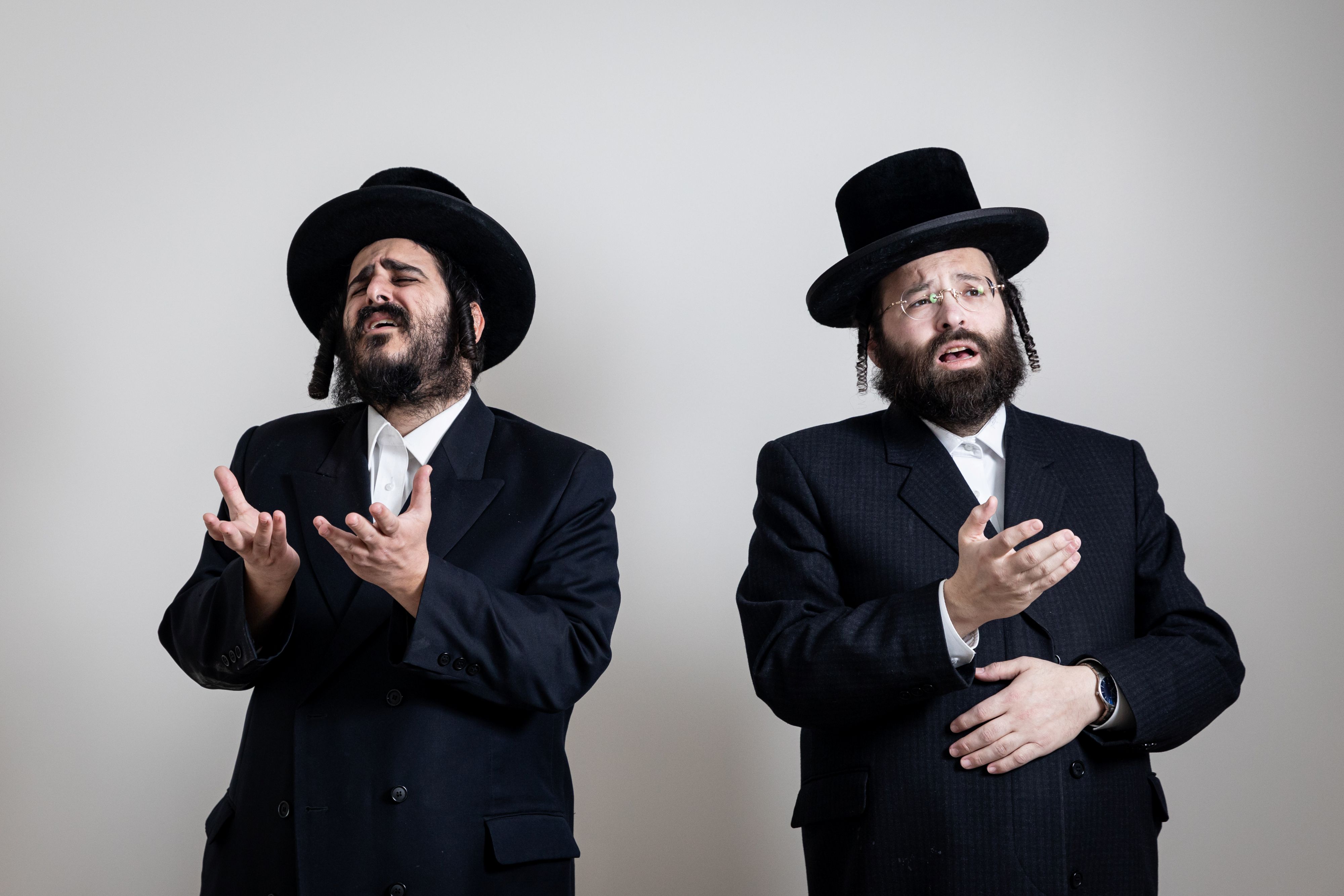 Two men wearing black hats and glasses.